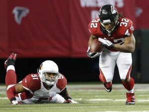 El RB Jacquizz Rodgers (32) deja a un lado al LB de los Cardenales  Kevin Minter (51) durante la segunda mitad el domingo en Atlanta. Foto: AP