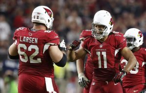 Larry Fitzgerald (11) y  Ted Larsen celebran una jugada durante la segunda mitad el domingo. Foto: AP