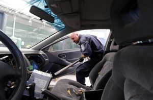 Customs and Border Protection officer Steve Delgado jabs at the dashboard of a Honda Accord with a large bar after finding more than 14 pounds of methamphetamine hidden behind the radio at the San Ysidro port of entry Thursday, June 27, 2013, in San Diego. The smuggling of the drug at land border crossings has jumped in recent years but especially at San Diego’s San Ysidro port of entry, which accounted for more than 40 percent of seizures in fiscal year 2012.  (AP Photo/Gregory Bull)