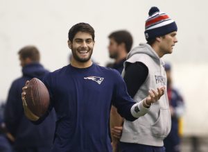 New England Patriots backup quarterback Jimmy Garoppolo, left, smiles while holding a football as Patriots starting quarterback Tom Brady stands by during a football team walkthrough in Foxborough, Mass., Friday, Jan. 23, 2015. (AP Photo/Elise Amendola)