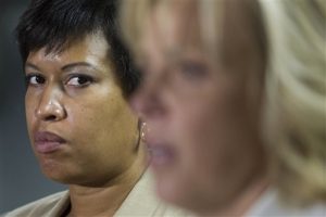 La alcaldesa de Washington, Muriel Bowser, escucha mientras la jefa de la policía, Cathy Lanier, interviene en una conferencia de prensa en Washington, el 21 de mayo de 2015, para informar sobre la investigación del misterioso asesinato de una familia adinerada de Washington y su servicio. (Foto AP/Cliff Owen)