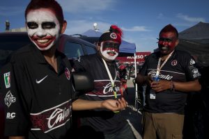 In this Oct. 7, 2012 photo, fans of the soccer team Xoloitzcuintles of Tijuana, or Xolos, wear their team's colors outside Caliente stadium as they wait for a game with Toluca in Tijuana, Mexico. The Xolos soccer team has become a sensation in Tijuana since they joined Mexico's first division soccer league in 2011. (AP Photo/Alex Cossio)