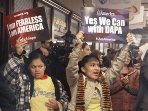 Manifestantes en pro de los inmigrantes sostienen carteles durante un acto en Houston el martes 17 de febrero de 2015 en el que se les asesoraría para solicitar permisos de trabajo y evitar ser deportados de acuerdo con las acciones ejecutivas anunciadas por el presidente Barack Obama. El letrero de la izquierda afirma: "Soy intrépido. Yo soy Estados Unidos", y el de la derecha dice: "Sí podemos con el DAPA" (Programa de Acción Diferida para Padres). (Foto AP/Pat Sullivan)