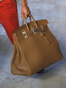 En esta foto del 25 de junio del 2011, un modelo carga una bolsa Birkin durante un desfile de modas en París. La cantante británica Jane Birkin le pidió a Hermes que retire su nombre de una versión de piel de cocodrilo del emblemático bolso, tras haber sido contactada por el grupo PETA en torno a prácticas "crueles" de matanza. (AP Foto/Jacques Brinon, Archivo)