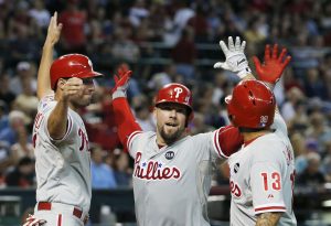 Cameron Rupp, de los Filis de Filadelfia, centro, celebra con sus compañeros de equipo Jeff Francoeur, izquierda, y Freddy Galvis su cuadrangular de tres carreras contra los Diamondbacks de Arizona. Foto: AP