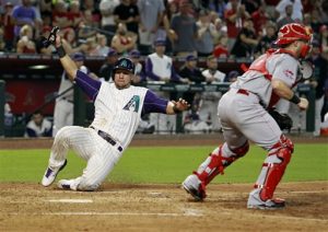 David Peralta (izquierda) de los Diamondbacks de Arizona se desliza para anotar una carrera en el quinto inning ante los Rojos de Cincinnati. Foto: AP