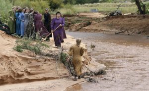 Miembros de la comunidad buscan a un lado de un riachuelo después de la inundación del pasado martes. Foto: AP