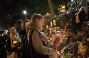 Unas personas acuden a dejar flores afuera del salón de conciertos Bataclan, donde hace unos días hubo un ataque terrorista. Foto: AP