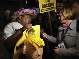 Una reportera entrevista a uno de los manifestantes que participaron en una protesta contra Trump antes de que el empresario condujera el programa Saturday Night Live. Foto: AP