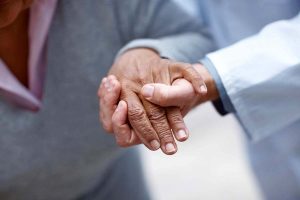 Closeup of an elderly woman's hand being held by a doctor , focus on hands