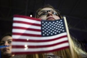 Una persona de la audiencia escucha al precandidato presidencial demócrata, Bernie Sanders, quien habla durante un acto de campaña en la Arena Centro Whittemore de la Universidad de New Hampshire, el lunes 8 de febrero de 2016, en Durham, New Hampshire. Los primeros votos en las primeras elecciones primarias del país serán contados el martes en tres diminutas comunidades de New Hampshire en las que la jornada electoral dura cinco minutos: Hart, Millsfield y, el más famoso, Dixville. (Foto AP/John Minchillo)