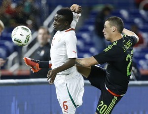 El mexicano Jesús Dueñas (20) y el senegalés Elimane Oumar Cisse (6) disputan un balón en el partido amistoso en Miami el miércoles 10 de febrero de 2016. (AP Foto/Wilfredo Lee)