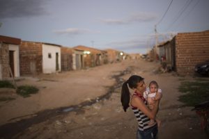 Angelica Pereira carga a su hija Luiza, quien nació con microcefalia, afuera de su casa en Santa Cruz do Capibaribe, en Brasil, el 6 de febrero de 2016. El virus zika se trasmite principalmente por mosquitos. La mayoría de las personas que contraen zika tienen pocos o ningún síntoma. Pero en el caso de las embarazadas, hay sospechas de que los fetos estén en riesgo de desarrollar microcefalia, un raro defecto congénito que causa daño cerebral y una cabeza anormalmente pequeña. (Foto AP/Felipe Dana)