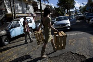 En esta imagen del 10 de marzo de 2016, Arturo Hernández, con un vestido, y Alex Marin y Kall, con un megáfono, presionan a conductores que dejaron sus autos mal aparcados para que se muevan de una calle atascada ante el Instituto Tecnológico Autónomo de México, en Ciudad de México. Ambos lideran a un grupo de voluntarios conocidos en YouTube, los "Supercívicos", que abochornan a los que incumplen las ordenanzas. (AP Foto/Rebecca Blackwell)